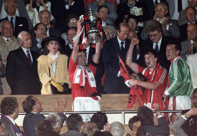 Manchester United captain Bryan Robson holds up the FA Cup in 1990