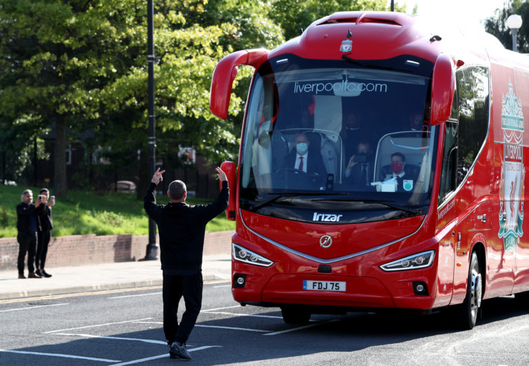 A fan gestures towards the Liverpool team coach outside the Etihad Stadium as the new Premier League champions arrived